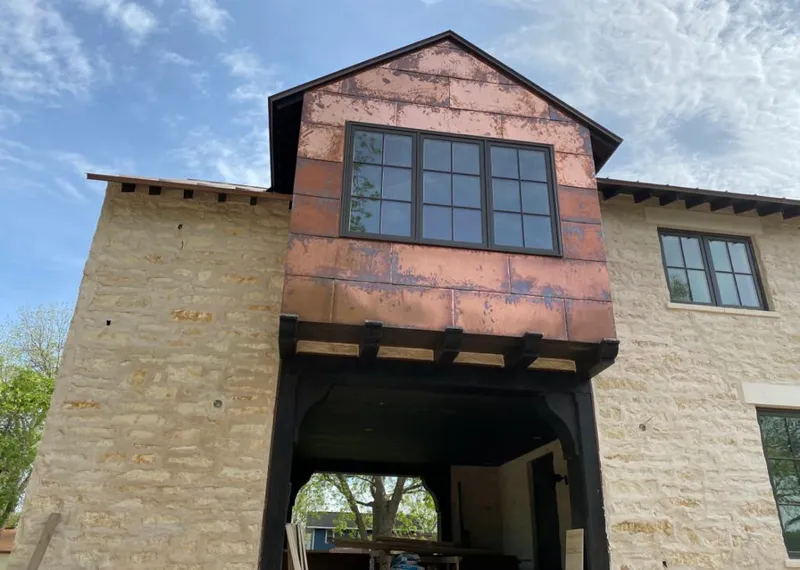 Copper metal panel facade on a stone building for Skylight Installation in Independence